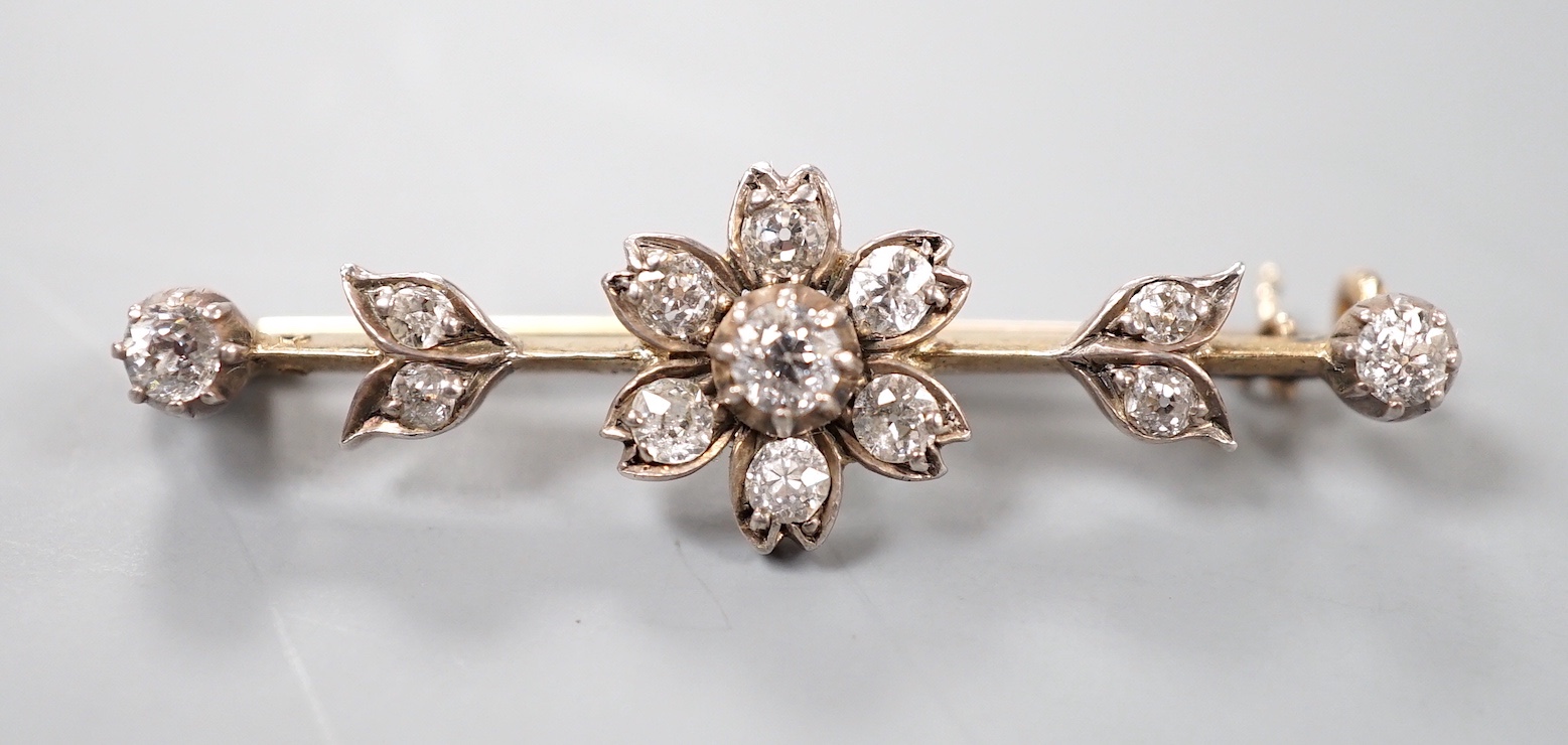 A Victorian yellow metal and diamond flowerhead cluster set bar brooch, 40mm, gross 3.8 grams.